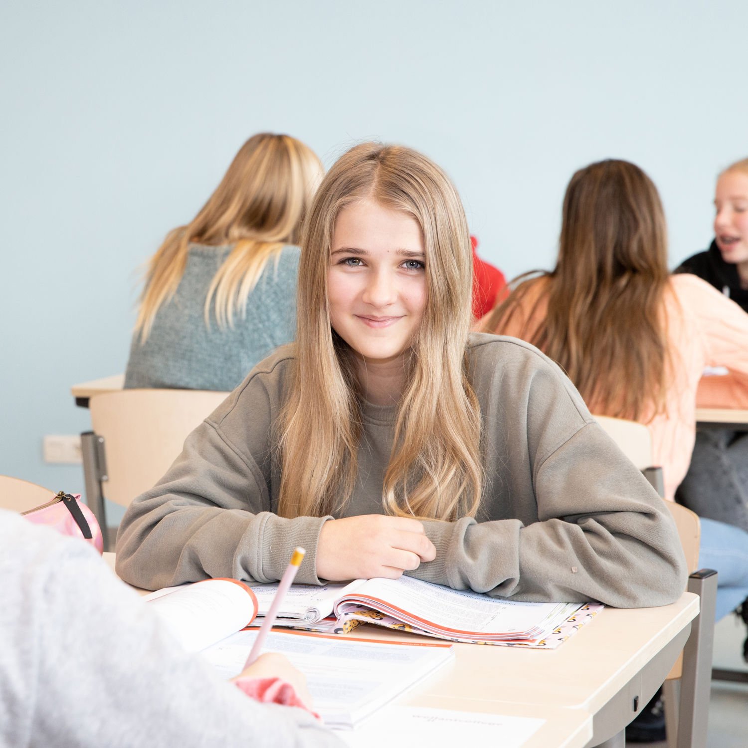 Docent leidt groep lachende studenten in klaslokaal