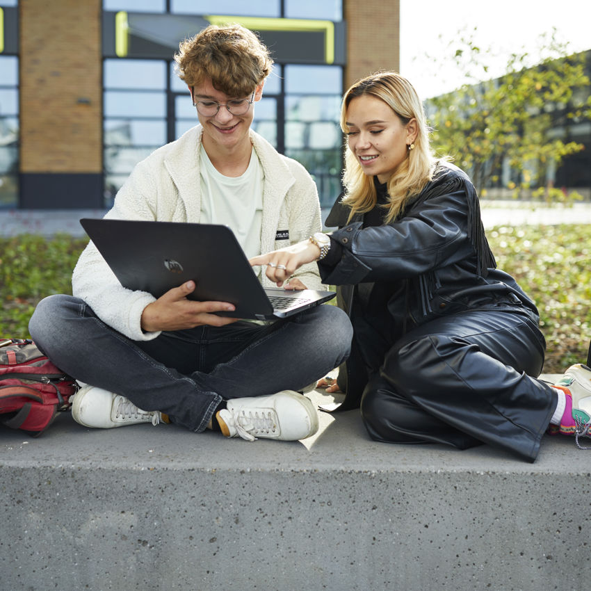 Docent leidt groep lachende studenten in klaslokaal
