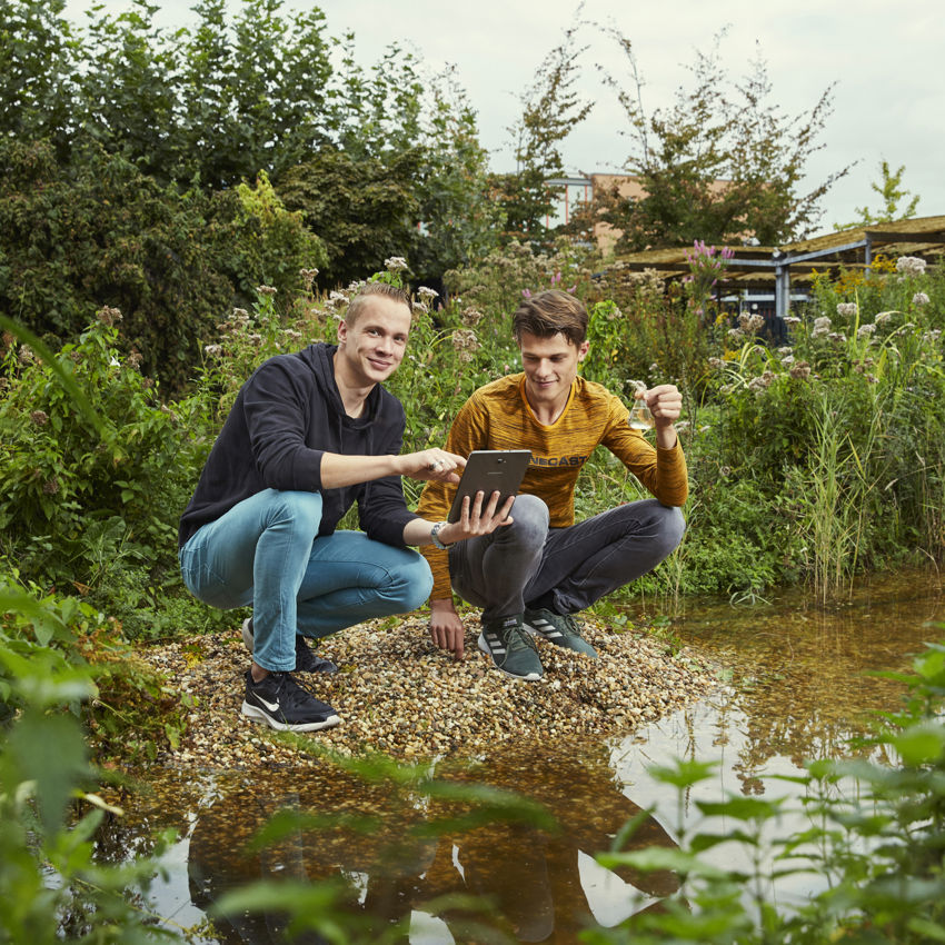 Docent leidt groep lachende studenten in klaslokaal