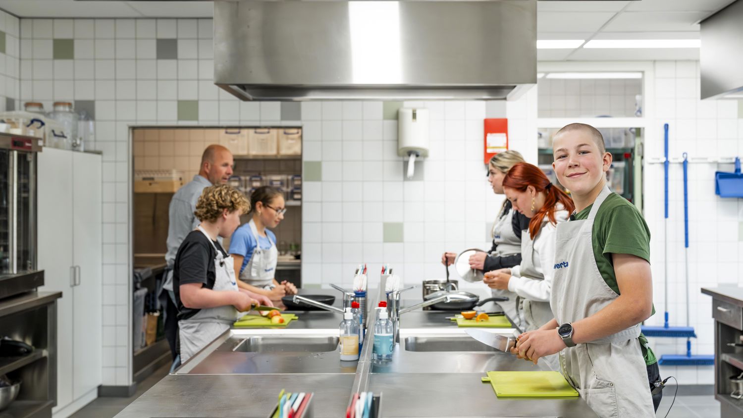 Docent leidt groep lachende studenten in klaslokaal