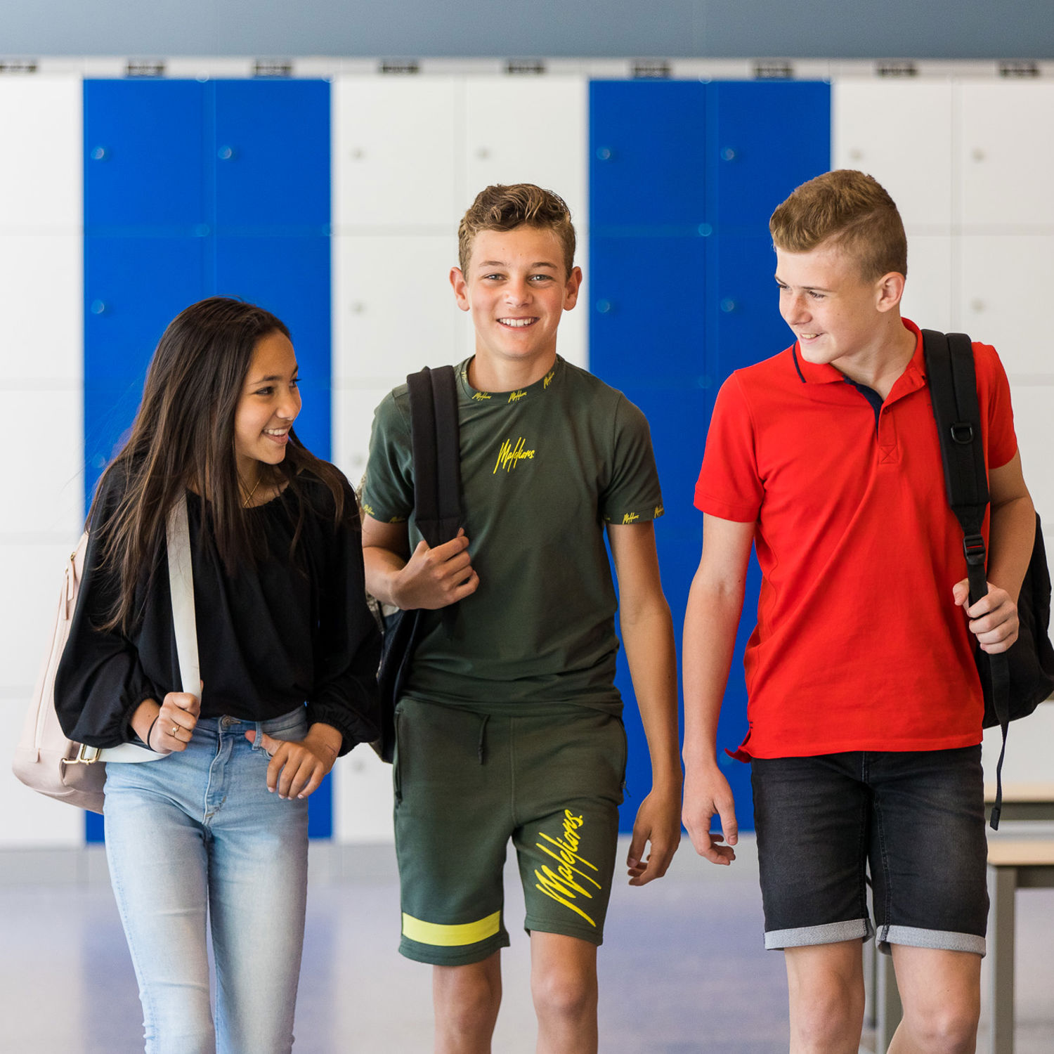 Meisje zittend op een bank voor kluisjes