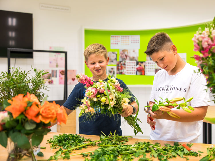 Docent leidt groep lachende studenten in klaslokaal