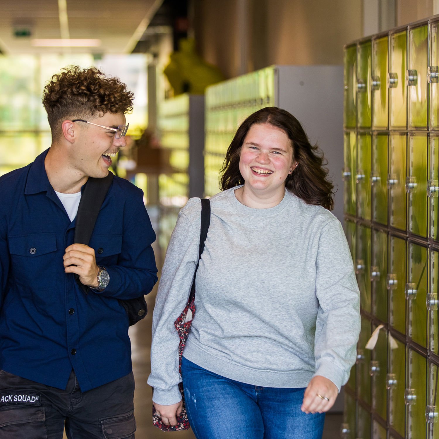 Meisje zittend op een bank voor kluisjes