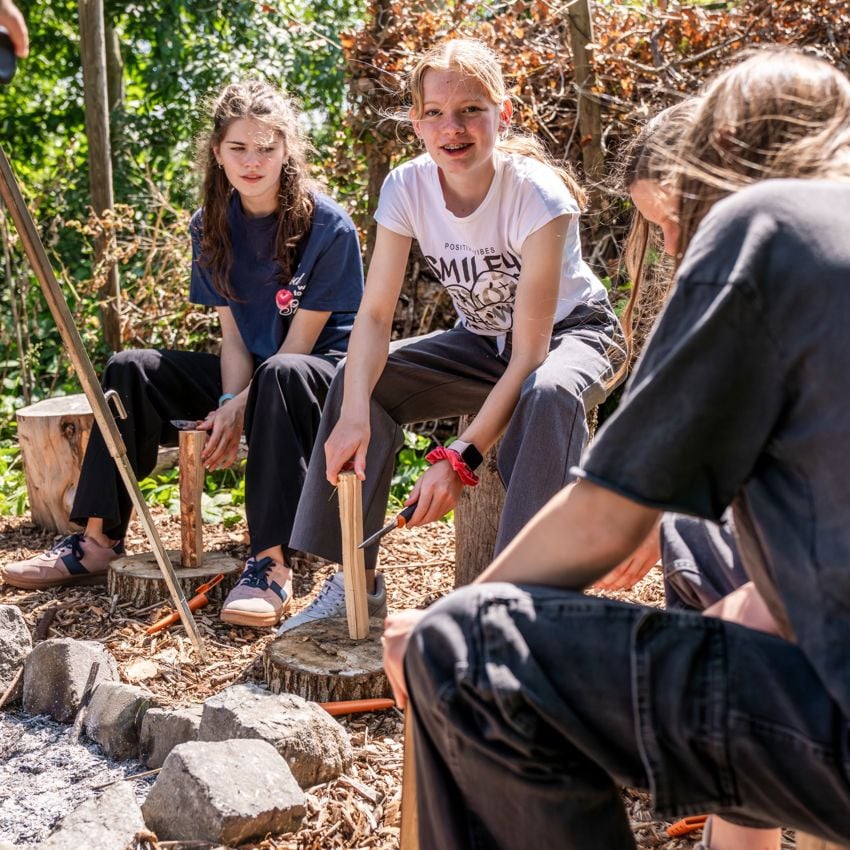 Docent leidt groep lachende studenten in klaslokaal